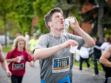 Philip Kijek uses some water to cool down during the 5K run at Tamarack Ottawa Race Weekend Saturday May 23, 2015.