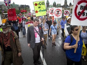 Hundreds walk along Wellington Street, heading to Parliament Hill to protest the government's proposed anti-terrorism legislation, Bill C-51, Saturday, May 30, 2015.