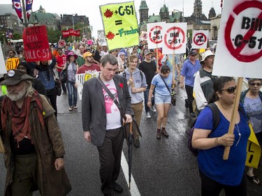 Hundreds walk along Wellington Street, heading to Parliament Hill to protest the government's proposed anti-terrorism legislation, Bill C-51, Saturday, May 30, 2015.