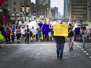 Hundreds walk along Wellington Street, heading to Parliament Hill to protest the government's proposed anti-terrorism legislation, Bill C-51, Saturday, May 30, 2015.