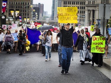 Hundreds walk along Wellington Street, heading to Parliament Hill to protest the government's proposed anti-terrorism legislation, Bill C-51, Saturday, May 30, 2015.