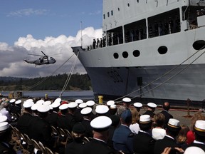 A Sea King helicopter conducts a fly past after the Canadian flag was lowered on the resupply ship HMCS Protecteur during a paying-off ceremony at CFB Esquimalt in Esquimalt, B.C., Thursday May 14, 2015.