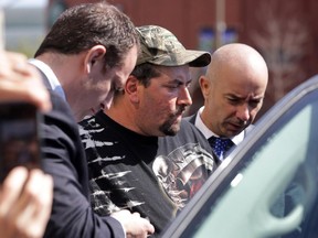 Sûreté du Québec detectives put Eric Boivin (centre) into a police van outside the courthouse in Gatineau Thursday, May 7, 2015.