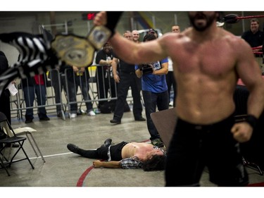 Suspended senator Patrick Brazeau lies on the ground outside the ring after being slammed through a table by Hannibal at the Great North Wrestling match on Saturday, May 30, 2015.