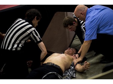 Other referees assist suspended senator Patrick Brazeau up after he was body slammed by pro wrestler Hannibal.