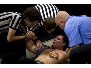 Other referees help suspended senator Patrick Brazeau up after he was body slammed by pro wrestler Hannibal.