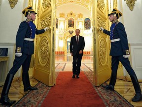 Russian President Vladimir Putin enters a hall to attend the presentation ceremony of the top military brass in the Kremlin in Moscow, Russia, Friday, March 28, 2014. Russia's president says Ukraine could regain some arms and equipment of military units in Crimea that did not switch their loyalty to Russia.