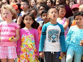 Young Mohan Gurung (second from right) sings his heart out with all of the other students (including, from left: Tessa Shaw, Riyam Hacuis and Fatima Mohammed-Jalile). About 100 kids from Arch Street Public School joined up with a band and students from nearby Canterbury High School to sing "We Are One" for the 11th Annual Music Monday, May 4, 2015 at Arch Street PS.   (Julie Oliver / Ottawa Citizen)