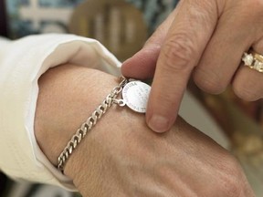 Amy Shives, who was diagnosed with Alzheimer&#039;s disease in 2011 and subsequently epilepsy, holds her Medicalert bracelet at her house, Wednesday, June 3, 2015, in Spokane, Wash. Since her diagnosis, Shives has since been involved with the Alzheimer&#039;s Association. She also says that in her case, the epilepsy is directly attributed to Alzheimer&#039;s disease. (AP Photo/Young Kwak)