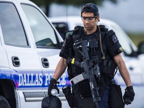 A Dallas SWAT officer  walks to his vehicle at the intersection of Interstate 45 and E Palestine Street, where police have cornered a suspect in a van on Saturday, June 13, 2015 in Hutchins, Texas.