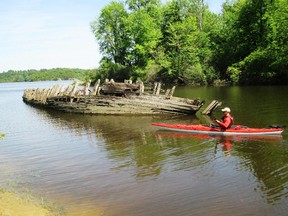 A kayaker gets a close up look at the hull of the 30-metre Ville de Vanier, a wooden schooner that may be the last one built before these ships disappeared from the St. Lawrence.