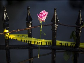A rose is affixed to a fence along a sidewalk memorial in memory of the shooting victims in front of Emanuel AME Church Saturday, June 20, 2015, in Charleston, S.C. The current brick Gothic revival edifice, completed in 1891 to replace an earlier building heavily damaged in an earthquake, was a mandatory stop for the likes of Booker T. Washington and the Rev. Martin Luther King Jr. Still, Emanuel was not just a church for the black community.