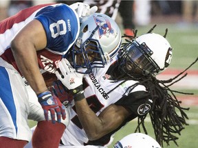 Ottawa Redblacks' Abdul Kanneh, right, tackles Montreal Alouettes' Nik Lewis (8) during first half CFL football action in Montreal, Thursday, June 25, 2015.
