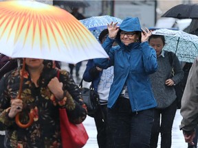 Pedestrians try to avoid the steady rain in Ottawa on Monday, June 8.