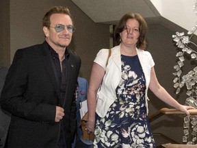 U2 frontman Bono arrives at the National Art Centre with NAC Director of Communications Rosemary Thompson in Ottawa on Monday, June 15, 2015. Bono is in Ottawa for a meeting with political leaders and non-profit organizations.