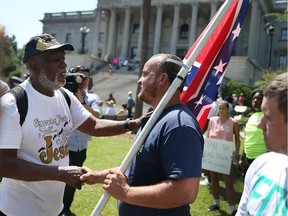 Ernest Branch, left,  shake hands with a man carrying a Confederate flag (who didn't want to provide his name) saying, that he respects the fact the guy likes the flag but that he is against the flag flying on the Capitol grounds on June 23, 2015 in Columbia, South Carolina.