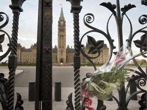 This October 23, 2014 file photo shows a bouquet of flowers  attached to the Queen's Gates outside Canada's House of Parliament in Ottawa , one day after multiple shootings in the capital city and Parliament buildings.