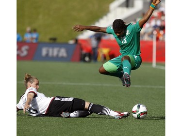Cote d'Ivoire's Fernande Tchetche (13) jumps over a slide tackle by Simone Laudehr (6) of Germany during the second half of their first match against Germany during the FIFA Women's World Cup at TD Place in Ottawa Sunday June 07, 2015.
