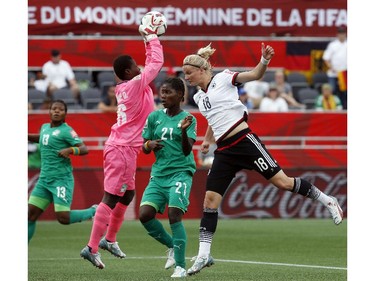 Cote d'Ivoire's goalkeeper Dominique Thiamale (16) grabs the ball out o the air while under pressure from a flying Alexandra Popp (18) of Germany during the first half of their first match of the FIFA Women's World Cup at TD Place in Ottawa Saturday June 07, 2014.