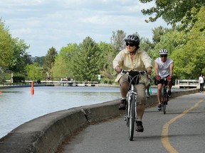 Cyclists pedal along the Rideau Canal near Carleton University on Colonel By Drive.