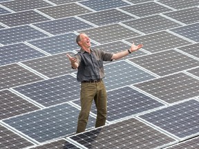 Dick Bakker, president of the Ottawa Renewable Energy Co-operative, stands among the solar panels on the roof of Franco-Cite School on Smyth Road.