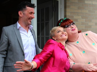 Fashion show model Whitney Fox and emcee, Joseph Cull, as Colleen Mary Margaret Margaret Mary Colleen, share a moment as MP Paul Dewar, who helped escort the models to the runway, watches  during the Sukhoo Sukhoo fashion show that took place during the garden party for Cornerstone on Sunday, June 7, 2015.