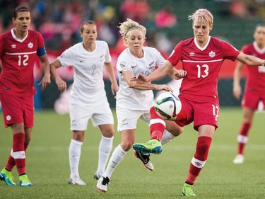 Canada's Sophie Schmidt (13) and  New Zealand's Betsy Hassett vie for the ball during their Group A match at the FIFA Women's World Cup at Commonwealth Stadium in Edmonton, Canada on June 11, 2015.