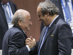 FILE - In this Friday, May 29, 2015 file photo, FIFA president Sepp Blatter after his election as President greeted by UEFA President Michel Platini, right,