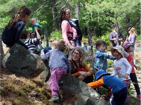 Marlene Power, centre, Executive Director at the Forest School Canada, takes part in rock climbing with preschoolers at Forest School at Wesley Clovers Park on the outskirts of Ottawa, Thursday, June 4, 2015.