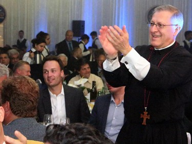 Fr. Alex Michalopulos gives a standing ovation to philanthropist Peter Foustanellas for matching every $5,000 donation made at the Gold Plate Dinner held at the Hellenic Meeting and Reception Centre on Tuesday, June 9, 2015.