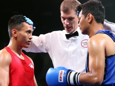 From left, amateur boxer Cedric Parina from Ottawa's Beaver Boxing Club prepares to fight his opponent, Kunal Pun from the Mississauga-based Kombat Arts at Ringside for Youth XXI, held at the Shaw Centre on Thursday, June 11, 2015.