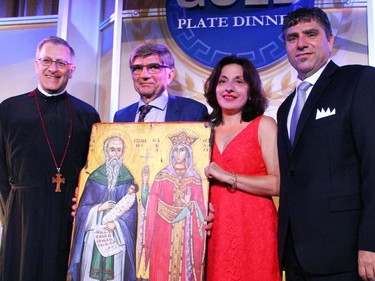 From left, Fr. Alex Michalopulos unveiled this icon of Saints Stylianos and Theodora as a gift to Steve Ramphos, outgoing chair of the 30th Annual Gold Plate Dinner, and his wife, Doris, joined on stage by Hellenic Community Council president Nicholas Lafkas on Tuesday, June 9, 2015, at the Hellenic Meeting and Reception Centre.