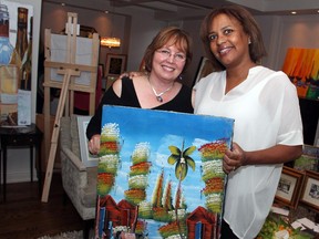 From left, Suzanne Jacobson, president of QuickStart - Early Intervention for Autism, with board member Cindy Harrison and one of her new purchases at the Art for Autism sale held Sunday, June 28, 2015, at the private home of Dr. Len and Marie Chumak in the Ottawa neighbourhood of Whitehaven, off Woodroffe Avenue. (Caroline Phillips / Ottawa Citizen)