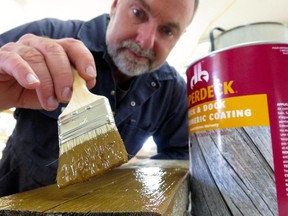 Steve Maxwell applies an elastomeric deck coating to a weathered, cracked piece of old deck lumber. The best elastomerics are thick enough to fill gaps and cracks and they lock down splinters.