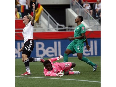 Germany's Anja Mittag (11) celebrates one of her two goals on Cote d'Ivoire's goalkeeper Dominique Thiamale (16) while Nina Kpaho (4) looks on during the first half of their first match of the FIFA Women's World Cup at TD Place in Ottawa Saturday June 07, 2014.