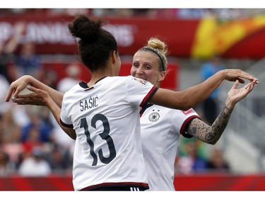 Germany's Celia Sasic (13) and Anja Mittag (11) celebrate on of their five goals against Cote d'Ivoire during the first half of their first match of the FIFA Women's World Cup at TD Place in Ottawa Saturday June 07, 2014.