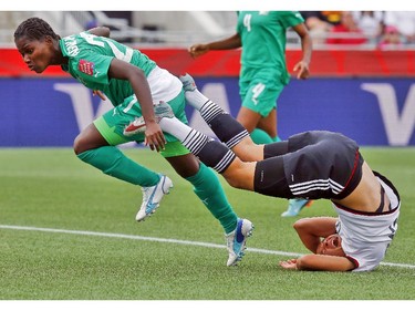 Germany's Celia Sasic (13) crashes to the pitch after colliding with Cote d'Ivoire's Sophie Aguie (21) and goalkeeper Dominique Thiamale (16) during the first half of their first match of the FIFA Women's World Cup at TD Place in Ottawa Saturday June 07, 2014.