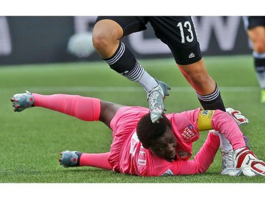Germany's Celia Sasic (13) steps over Cote d'Ivoire's goalkeeper Dominique Thiamale (16) during the first half of their first match of the FIFA Women's World Cup at TD Place in Ottawa Saturday June 07, 2014.