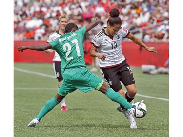 Germany's Celia Sasic (13) tries to get around Cote d'Ivoire's Sophie Aguie (21) during the first half of their first match of the FIFA Women's World Cup at TD Place in Ottawa Saturday June 07, 2014.