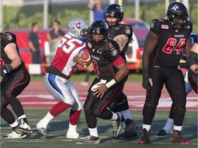 Ottawa Redblacks quarterback Henry Burris runs away from Montreal Alouettes defensive end Gabriel Knapton during the first quarter on Saturday, June 13, 2015 in Quebec City.