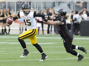 Hamilton Tiger-Cats quarterback Jeff Mathews (15) brushes off Ottawa Redblacks linebacker Travis Brown (43) before delivering a touchdown pass to Hamilton Tiger-Cats wide receiver Terrence Toliver (80) during the first half of their CFL game in Hamilton, Ont., Monday, June 8, 2015.