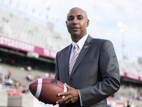 CFL Commissioner Jeffrey Orridge holds a football with his signature on it.