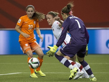Canada forward Josee Belanger knocks the ball away from Netherlands midfielder Danielle Van De Donk in front of Canada goalkeeper Erin McLeaod during first half Women's World Cup soccer action Monday, June 15, 2015 in Montreal.