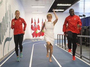 A NEW MEANING TO 'RUNNING FOR OFFICE'? Ontario Premier Kathleen Wynne, centre, takes part in a warm up routine with 400-metre runner Jenna Martin-Evans, left, and 100-metre sprinter Sam Effah. The premier visited members of Canada's track and field team at the Pan Am athlete's village in Toronto on Thursday.