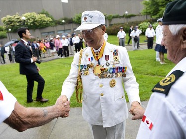 Korean member of Korea Veteran's Association, Charles Kim, shake hands with Canadian veterans before the 62nd anniversary of the Korean War Armistice at Monument to Canadian Fallen in Ottawa on Sunday, June 21, 2015.
