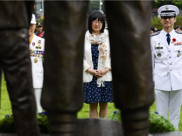 (L-R) Korean member of Korea Veteran's Association, Charles Kim, Senator Yonah Martin, and Korean military attache colonel Jang Min Choi, seen through the monument during the 62nd anniversary of the Korean War Armistice at Monument to Canadian Fallen in Ottawa on Sunday, June 21, 2015.