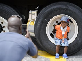 Mikai Bafi-Yeboa checks out one of the trucks as his father takes a photo at Mothercraft Touch a Truck event held at Lincoln Fields shopping centre on Sunday, June 14, 2014.