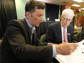 NDP MP Paul Dewar, left, shows National Capital Commission board chair Russell Mills a letter which he says is from Conservative ministers John Baird and Jason Kenney at a public meeting at the National Capital Commission HQ in Ottawa Thursday June 25, 2015. (Darren Brown/Ottawa Citizen)