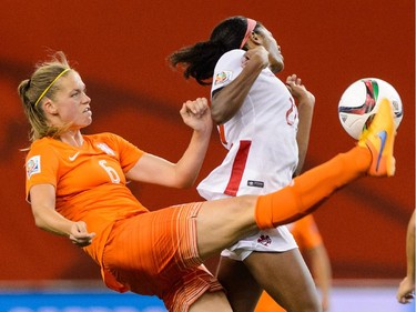 MONTREAL, QC - JUNE 15:  Anouk Dekker #6 of the Netherlands kicks the ball in front of Ashley Lawrence #22 of Canada during the 2015 FIFA Women's World Cup Group A match at Olympic Stadium on June 15, 2015 in Montreal, Quebec, Canada.