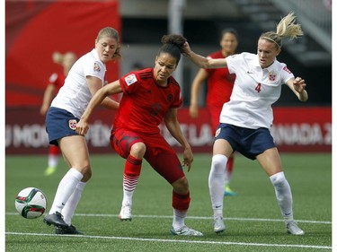 Norway's Maren Mjelde (6) and Gry Tofte IMS (4) try to defend Germany's Nadine Angerer (13) during the first half of their match during the 2015 FIFA Women's World Cup at Lansdowne Stadium Thursday June 11, 2015.